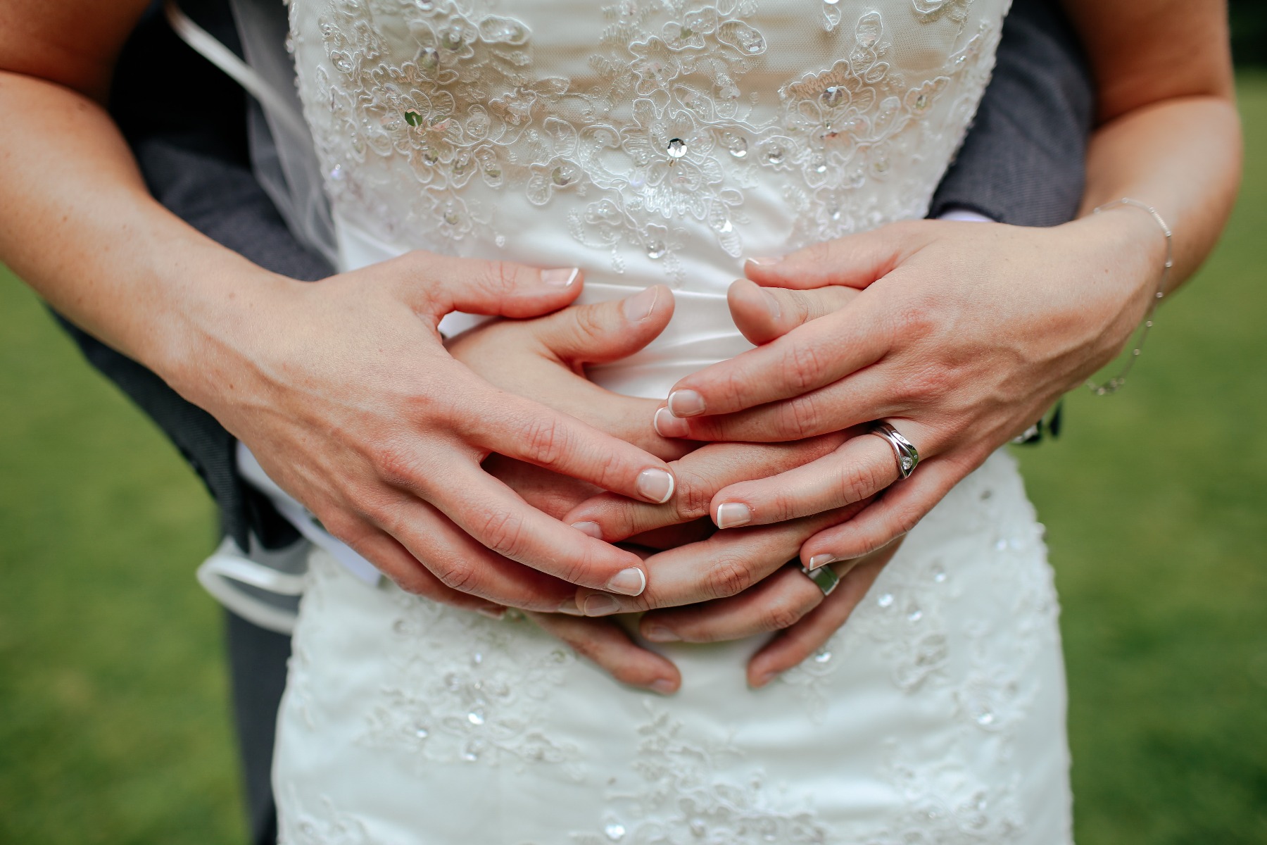 Bride with her arms wrapped around her husband, showing off her beautiful ring. 