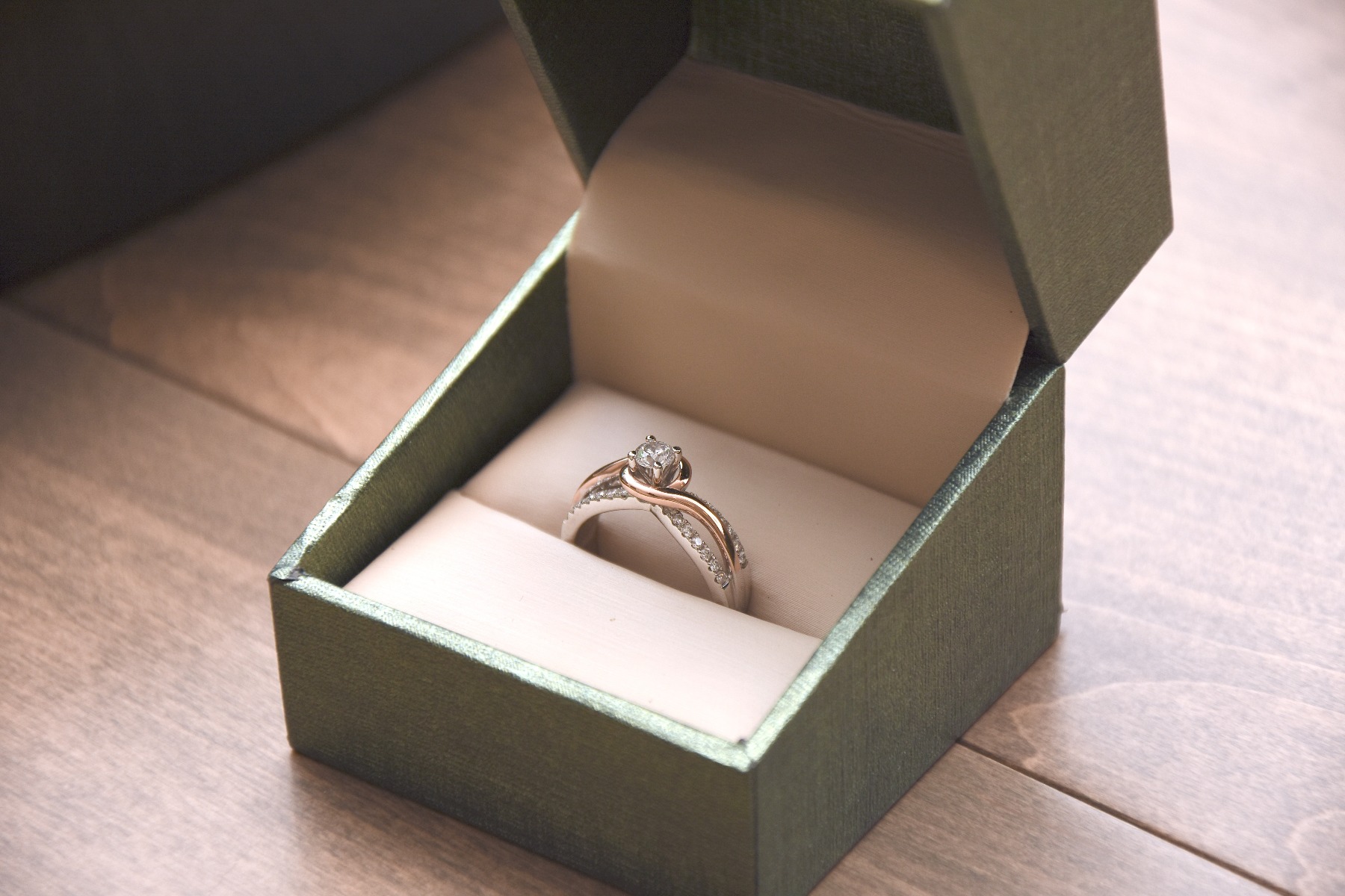 Beautiful engagement ring sitting on a wood table