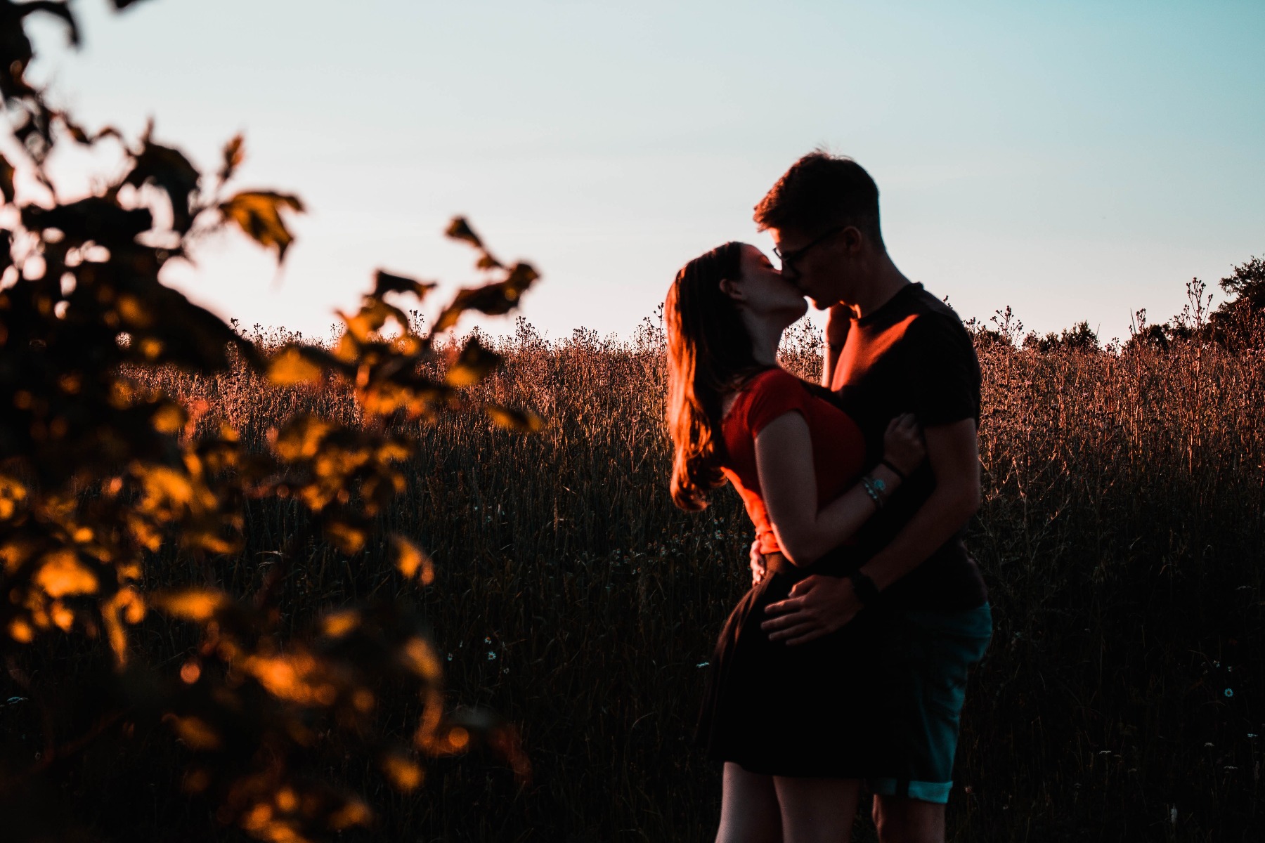 A man and a woman embracing each other in the sunset