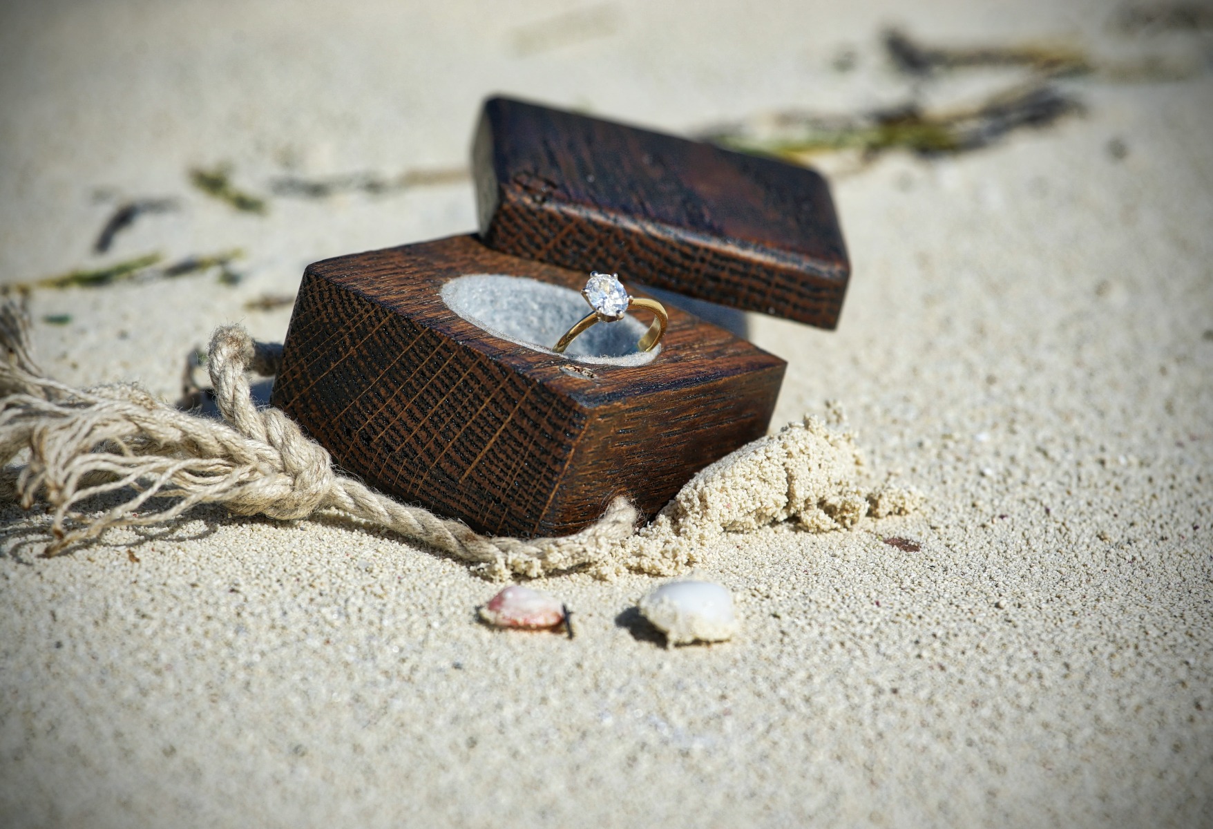 Engagement ring in an engagement box in the sand on a beach